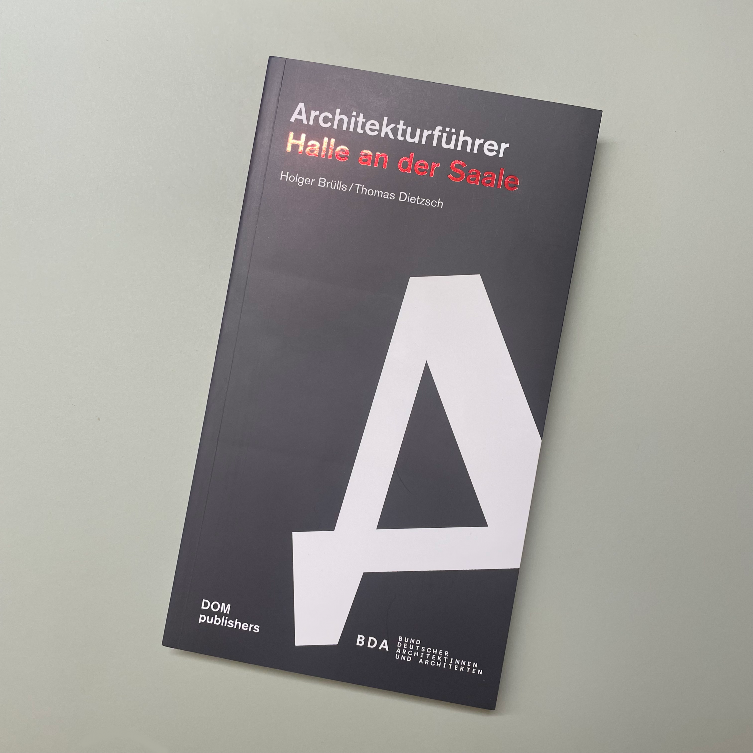 Buch "Architekturführer Halle an der Saale" vor grauem Hintergrund